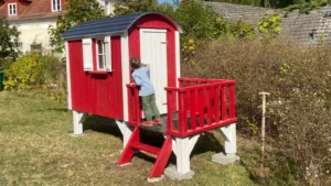 Kinderspielhaus Pünktchen & Anton - Bauwagen aus Holz mit Terrasse & Hochebene